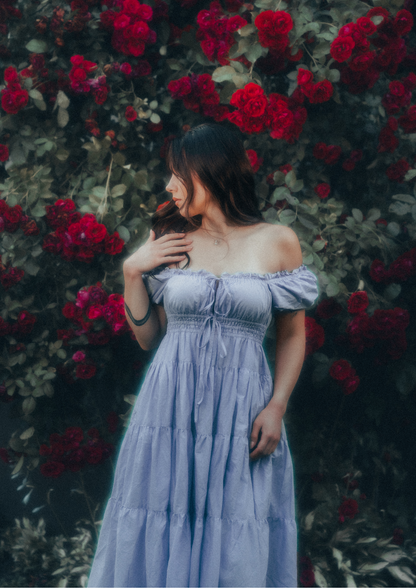 MODEL WEARS ERAVELA PENELOPE MIDI DRESS LILAC IN ENCHANTED ROSE GARDEN