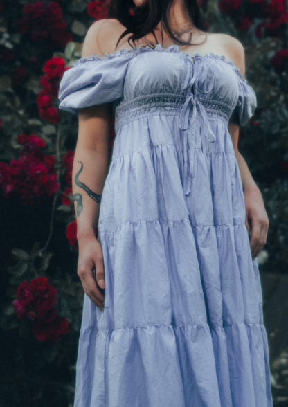MODEL WEARS ERAVELA PENELOPE MIDI DRESS LILAC IN ENCHANTED ROSE GARDEN
